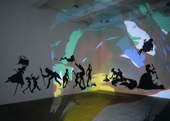 Darkytown Rebellion
Kara Walker. 2001 C.E. Cut paper and projection on wall.
Black silhouettes against colorful background, sharp lines, distinct and defined shapes. The actual subject of the work is meant to reflect the antebellum South during the time of slavery. Many southern African-American stereotypes are still present today and Walker hoped to make viewers realize how subconsciously they had these premeditated ideas about the figures and the assumptions about race they automatically made because of popular culture. Darkytown Rebellion
Kara Walker. 2001 C.E. Cut paper and projection on wall.
Black silhouettes against colorful background, sharp lines, distinct and defined shapes. The actual subject of the work is meant to reflect the antebellum South during the time of slavery. Many southern African-American stereotypes are still present today and Walker hoped to make viewers realize how subconsciously they had these premeditated ideas about the figures and the assumptions about race they automatically made because of popular culture.