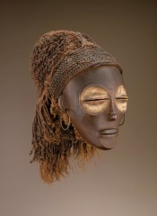 Female Pwo Mask
Chokwe Peoples, Late 19th century, wood fiber pigment, metal
Female masks used by men in ritual dances
Male dancers are covered with their identities masked, dressed as women and had hair braided
Men also move like women in the ritual
Chokwe a matriarchal society showing importance of women
Depicts female ancestors
Mask usually buried with user
Characterized by: Large eye sockets, pushed in chin, slender nose, high forehead, balanced features, almost closed eyes Female Pwo Mask
Chokwe Peoples, Late 19th century, wood fiber pigment, metal
Female masks used by men in ritual dances
Male dancers are covered with their identities masked, dressed as women and had hair braided
Men also move like women in the ritual
Chokwe a matriarchal society showing importance of women
Depicts female ancestors
Mask usually buried with user
Characterized by: Large eye sockets, pushed in chin, slender nose, high forehead, balanced features, almost closed eyes