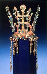 Gold and jade crown
Three Kingdoms Period, Silla Kingdom, Korea. Fifth to sixth century C.E. Metalwork
The general structure and imagery of this set echo the regalia used by rulers of the many nomadic confederations that roamed the Eurasian steppes for millennia, and, to a lesser extent, pieces found in China. However, Silla tombs such as Hwangnam Daechong have yielded larger quantities and more spectacular gold adornments. Gold and jade crown
Three Kingdoms Period, Silla Kingdom, Korea. Fifth to sixth century C.E. Metalwork
The general structure and imagery of this set echo the regalia used by rulers of the many nomadic confederations that roamed the Eurasian steppes for millennia, and, to a lesser extent, pieces found in China. However, Silla tombs such as Hwangnam Daechong have yielded larger quantities and more spectacular gold adornments.